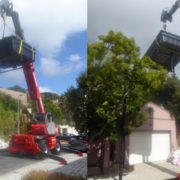 Mobile crane telehandler lifting a swimming pool over a wall