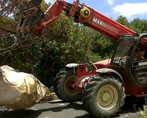 The Manitou telehandler carrying rocks from a building site.