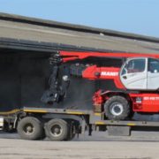 Hired mobile crane transported on flat bed truck