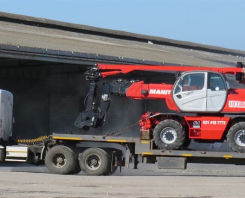 Hired mobile crane transported on flat bed truck