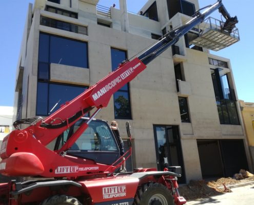 Mobile crane lifting furniture to apartment